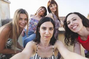 grupo de hembra amigos tomando un selfie con teléfono inteligente foto