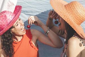 couple female friends having fun while eating cherries on the roofs photo