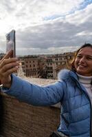 hermosa maduro mujer turista tomando un selfie en frente de plaza di España en Roma foto