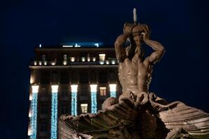 noche escena de tritón fuente en plaza barberini en Roma foto