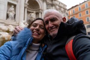 contento medio Envejecido Pareja en vacaciones tomando un selfie en frente de un famoso trevi fuente en Roma foto