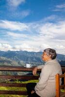 Senior woman tourist looking at the amazing landscapes of the Central Ranges on the ascent to the High of Letters between the cities of Fresno and Manizales in Colombia photo