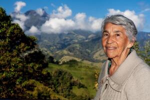 mayor mujer turista mirando a el increíble paisajes de el central rangos en el ascenso a el alto de letras Entre el ciudades de Fresno y manizales en Colombia foto