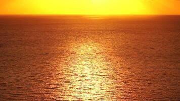 Sea water surface. Aerial view on golden sea water at sunset. Sun glare. Abstract nautical summer ocean nature. Holiday, vacation and travel concept. Nobody. Slow motion. Weather and climate change video