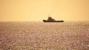 Tug boat in open calm sea, heading back to port at sunset, helps large container ships maneuver. Aerial view, maritime industry, oceanic transportation or business concepts. video