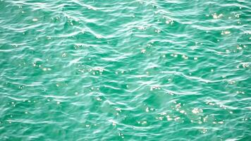 Sea water surface. Aerial view on clear azure sea water. Sun glare. Abstract nautical summer ocean nature. Holiday, vacation and travel concept. Nobody. Slow motion. Weather and climate change video