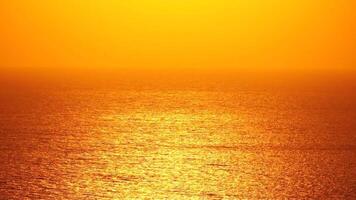 Sea water surface. Aerial view on golden sea water at sunset. Sun glare. Abstract nautical summer ocean nature. Holiday, vacation and travel concept. Nobody. Slow motion. Weather and climate change video