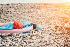 Pilates magic ring and rubber band on yoga mat near sea. Female fitness yoga concept. Healthy lifestyle harmony and meditation. photo