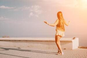 Woman summer dance. Silhouette of a happy woman who dances, spins and raises her hands to the sky. A playful young woman enjoys her happy moment dancing in the rays of the golden sun. photo