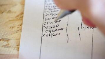 Man, Paper, Accounting. Hand of man with pen in motion, marking numbers on paper for financial record-keeping. video