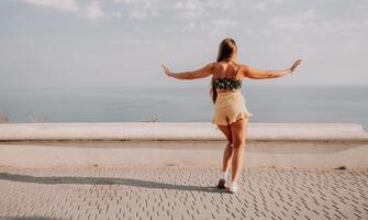 Woman summer dance. Silhouette of a happy woman who dances, spins and raises her hands to the sky. A playful young woman enjoys her happy moment dancing in the rays of the golden sun. photo