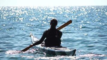 femme mer kayak. content souriant femme dans kayak sur océan, pagayer avec en bois rame. calme mer l'eau et horizon dans Contexte. actif mode de vie à mer. été vacances. video