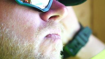 Man eating ice cream. Close-up portrait of young hipster man in sunglases eating ice cream in summer hot weather on the beach, have fun and good mood. video