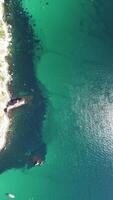 Aerial view from above on calm azure sea and volcanic rocky shores. Small waves on water surface in motion blur. Nature summer ocean sea beach background. Nobody. Holiday, vacation and travel concept video