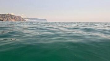 mar água superfície fundo. baixo ângulo Visão a partir de caiaque, Câmera moscas sobre a Claro verde mar água. ninguém. feriado lazer conceito. abstrato náutico verão oceano natureza. lento movimento. video