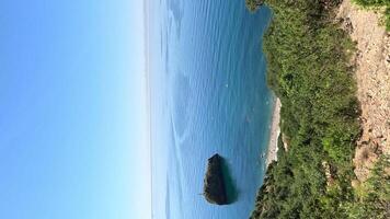 aéreo Visão em calma azul mar e vulcânico rochoso margens. pequeno ondas em água superfície dentro movimento borrão. natureza verão oceano mar de praia fundo. ninguém. feriado, período de férias e viagem conceito video