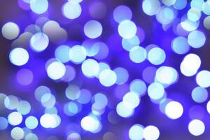 Blurred bokeh magical background. Blue and white gradient. Shimmer confetti pattern. Abstract christmas and new year holidays effect. Festive blue luminous background. photo