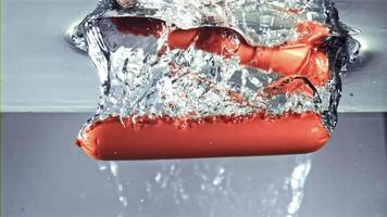 A red writing implement is floating in a pool of liquid, resembling lipstick. This unusual event captures the vibrant color against the blue background video