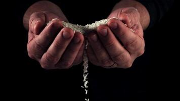 Super slow motion from men's palms pours raw rice . High quality FullHD footage video
