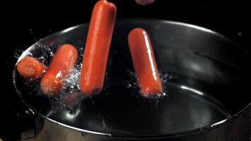 Super slow motion sausages fall into a pot. High quality FullHD footage video