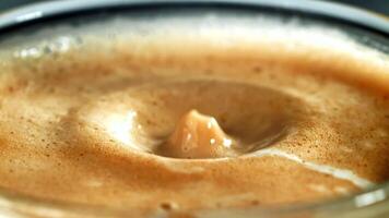 A closeup shot of a glass of coffee with a unique hole in the middle, showcasing the rich liquid inside. A creative twist on a classic drink presentation video