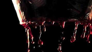 super lent mouvement rouge du vin les flux vers le bas le des murs de le verre. sur une noir Contexte. filmé sur une haute vitesse caméra à 1000 fps.haut qualité Full HD métrage video