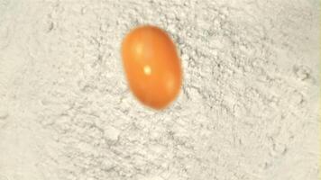 Super slow motion fresh egg falls into the flour. Macro background. Filmed on a high-speed camera at 1000 fps. video