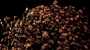 The super slow motion of the coffee beans soars up and falls. On a black background.Filmed on a high-speed camera at 1000 fps. High quality FullHD footage video