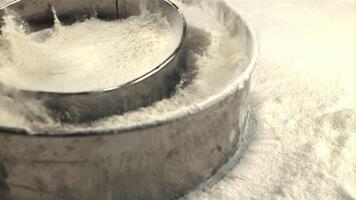 Super slow motion of the sieve with flour falls on the table. On a white background. Filmed on a high-speed camera at 1000 fps.High quality FullHD footage video