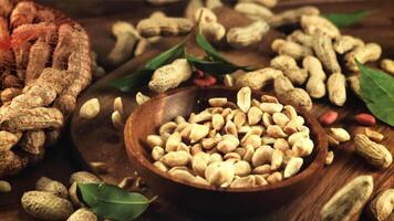 A wooden plate of peanuts falls on the table. On a wooden background. Filmed is slow motion 1000 frames per second. video