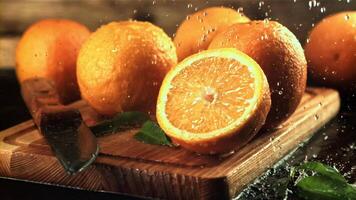 Drops of water fall on fresh oranges. On a wooden background. Filmed is slow motion 1000 fps. video