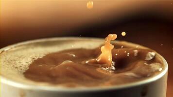 Drops fall into a mug of coffee with milk. Against a dark background.Filmed is slow motion 1000 frames per second. High quality FullHD footage video