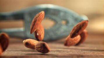 Almonds fall to the table. On a wooden background.Filmed is slow motion 1000 fps. High quality FullHD footage video