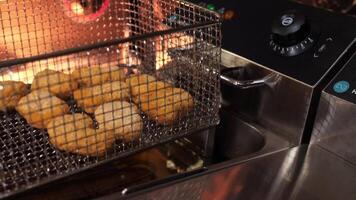 A basket with nuggets is lowered into hot oil video
