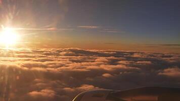 volante su un' aereo durante un' bellissimo tramonto Visualizza al di sopra di il nuvole. viaggio concetto. video