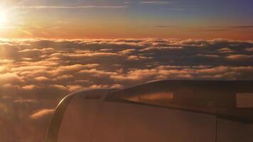 volador en un avión durante un hermosa puesta de sol ver terminado el nubes viaje concepto. video