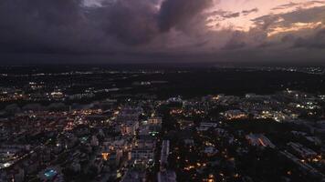 mozzafiato aereo prospettiva catturato di fuco vetrine popolare costiero città durante sbalorditivo viola tramonto, migliorata di splendore di vivace città luci. volo inoltrare. video