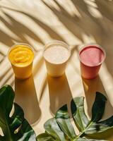 Some cups of smoothies, minimalist background, shadow leafs photo