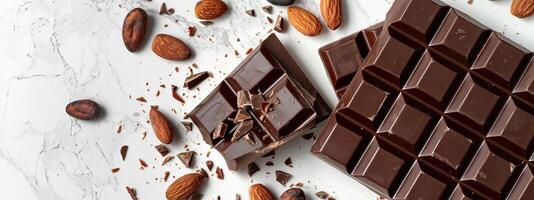 Chocolate bar with cacao beans and almonds scattered around it photo