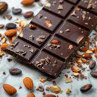 Chocolate bar with cacao beans and almonds scattered around it photo