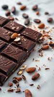 Chocolate bar with cacao beans and almonds scattered around it photo