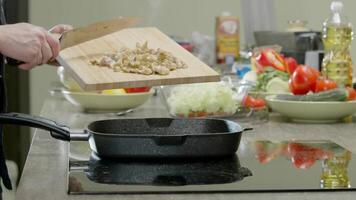 Koch setzt Stücke von Hähnchen im ein braten schwenken zu Koch ihnen. schließen hoch. schleppend Bewegung. video