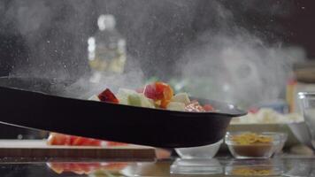 We cook baked vegetables. The chef is stirring the peppers in a hot frying pan, which is steaming. Asian or vegetarian dishes. The chef prepares a vegetable stew in a frying pan. slow motion. Close up. Slow motion. video