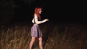 A young girl with red hair, wearing a plaid miniskirt, got lost in the night and anxiously walked away from her pursuers. Full shot. 4k video