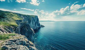A coastal cliff overlooking the vast expanse of the ocean photo