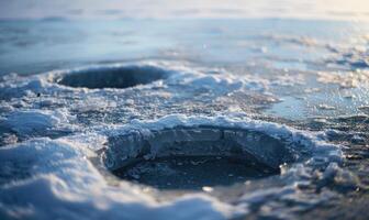 A pair of ice fishing holes drilled into the frozen surface of a lake photo