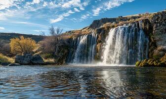 A picturesque waterfall cascading into a spring-fed lake photo