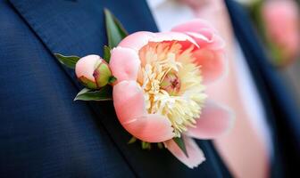 A peony boutonniere pinned to a groom's suit jacket photo