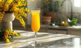 Cocktail in a glass goblet with mimosa branches in the background photo