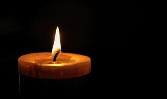 Close-up of a candle's gentle flicker illuminating a serene setting photo